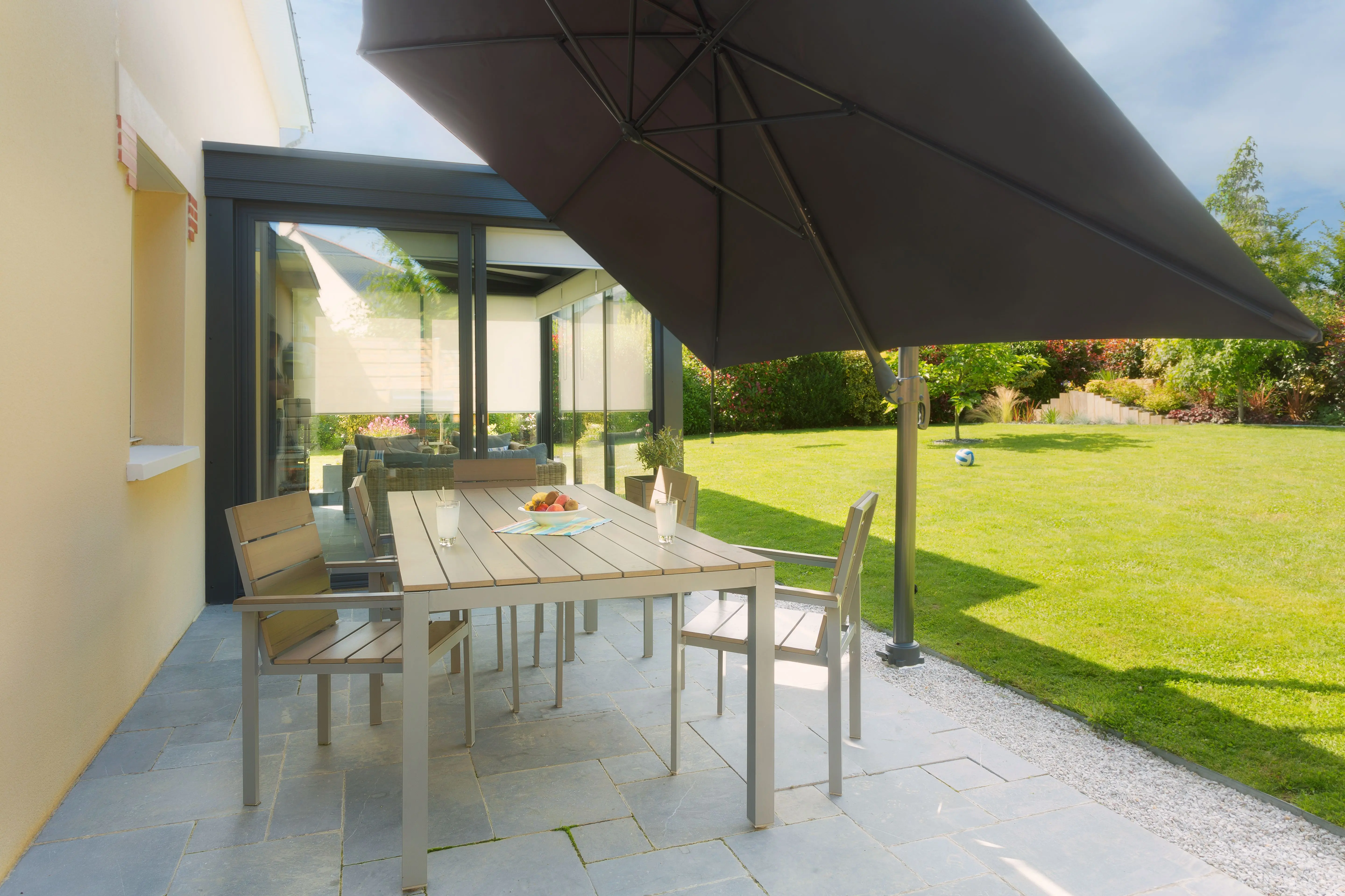 Parasol installed on a terrace without a heavy or bulky base thanks to a discreet ground anchor